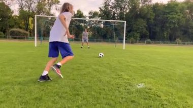 Top Sporcu 'nun kontrolünde. Futbol topu olan çocuk. Çocuk futbol topuyla hokkabazlık yapıyor. Çocuk futbol maçı rüyası. Parkta spor eğitimi. Çocuk top çeviriyor. Sağlıklı bir yaşam tarzı. Yüksek kalite 4k görüntü
