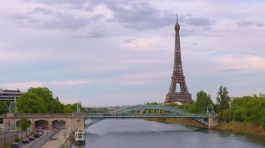 Eiffel Tower on Champs de Mars in Paris, France. Blue cloudy sky at summer day with green lawn. High quality 4k footage