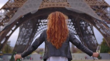 Paris 'te Eyfel Kulesi' nin yakınındaki çekici bir kız şampanya içer ve hayallerinin gerçekleşmesine sevinir. Dünyanın en çok ziyaret edilen şehrinde bir turist. Yüksek kalite 4k görüntü