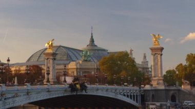 Paris 'teki Alexandre Köprüsü gün batımında aydınlandı. Arka planda Grand Palais. Trafik sıkışık. Paris, Fransa. Zaman aşımı. Yüksek kalite 4k görüntü