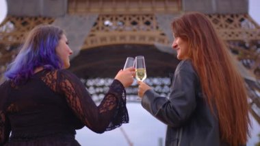 Güzel mutlu çift Paris 'teki Eyfel Kulesi' nin önünde bir akşam düğününü kutluyor. Romantik bir yerde şampanya içen bir çift. Yüksek kalite 4k görüntü