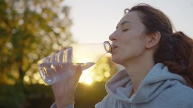 Güzel bir kadın verimli bir çalışmadan sonra dinlenip su içiyor. Yüksek kalite 4k görüntü