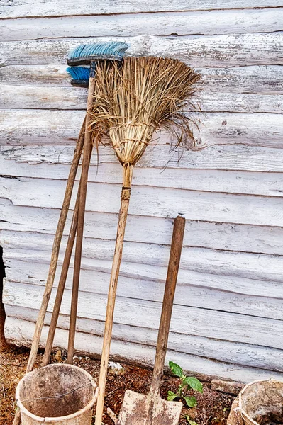 古巴文纳莱斯农业区一座白色农舍的墙上靠着两把扫帚和一把铲子 — 图库照片