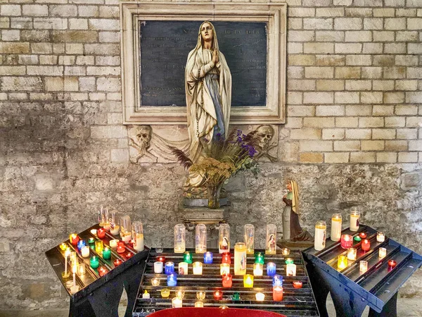 アルル大聖堂の像の足元で燃えている祈りのろうそくの配列 — ストック写真