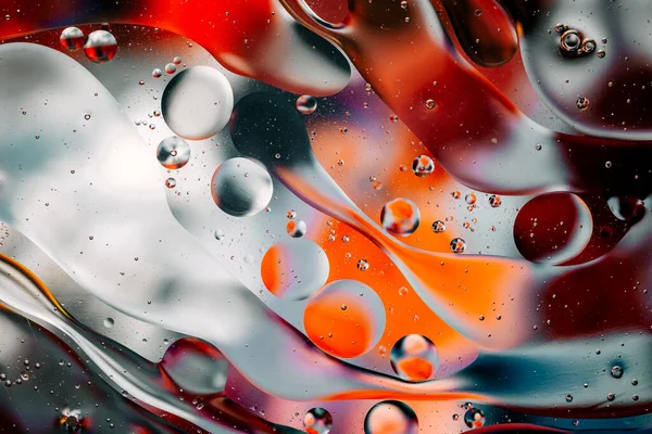 Su yüzeyindeki yağ damlacıklarının hareketine yakın çekim. Su yüzeyindeki yağ damlalarının renkli ve soyut makro arkaplanı