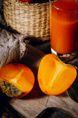 Bir grup olgun portakal meyvesi. Ahşap bir tahtanın üzerinde hurma meyvesi, kırsal bir arka plan..