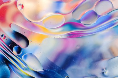 Su yüzeyindeki yağ damlacıklarının hareketine yakın çekim. Su yüzeyindeki yağ damlalarının renkli ve soyut makro arkaplanı