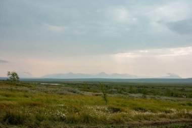 Kuzey Kutbu tundrasında uzak, vahşi bir plato. Dağların uzak dış hatlarının arka planına karşı.