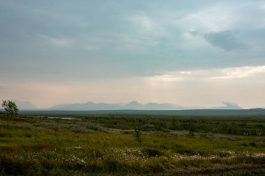 Kuzey Kutbu tundrasında uzak, vahşi bir plato. Dağların uzak dış hatlarının arka planına karşı.