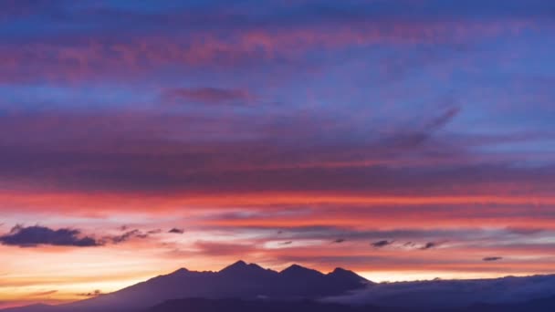 Světlé scenérie Včasný pohled na červený a růžový západ slunce, barevné oblačnosti nad klidným horským ostrovem — Stock video