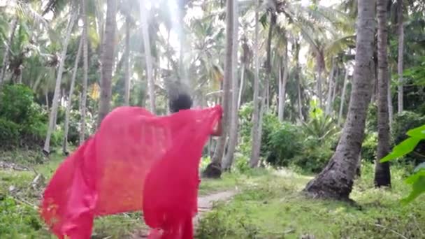 Elegante sensuele vrouw in lange rode romantische jurk ontsnappen in het regenwoud, majestueuze jungle sprookje — Stockvideo