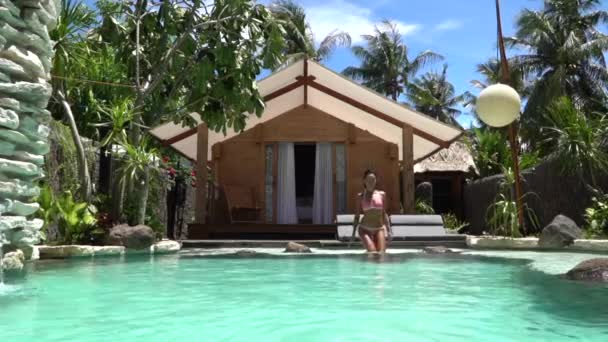 Женщина, заходящая в бассейн на вилле на острове Эль-Фаллуджа, отдых и самочувствие — стоковое видео