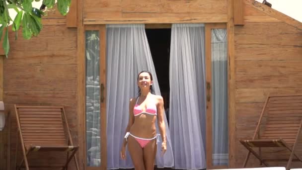 Відкриваючи знімок сяючої красивої жінки в купальнику, що виходить від розкішної вілли до басейну, тропічний відпочинок — стокове відео