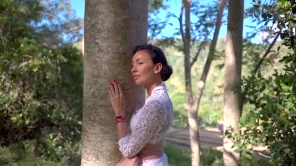 Porträtt av vacker kvinna kramar trädstammen i skogen, älskar naturen koncept, samband med naturen — Stockvideo