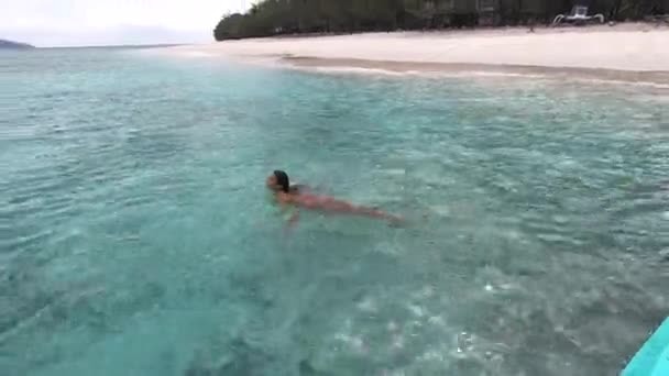 Mujer relajada nadando, tumbada en las claras olas del océano, disfrutando de la tranquilidad y la naturaleza tropical de la isla — Vídeos de Stock