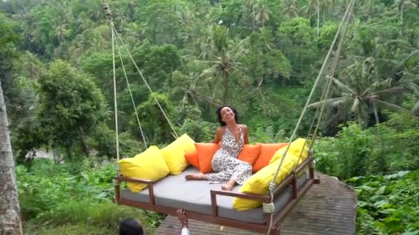 Щаслива жінка насолоджується затишними літаючими гойдалками в тропічних лісах, чисте щастя на тропічних літніх канікулах — стокове відео
