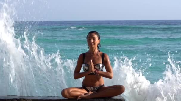 Спокойствие и расслабленность женщины, йога и медитация оздоровление тренировки на побережье океана, большие волны брызги — стоковое видео