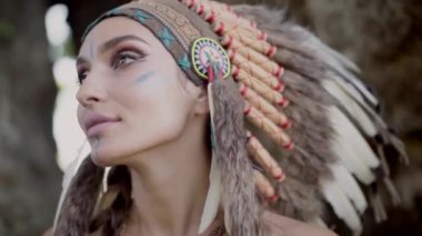 Vahşi doğada, etnik kültürde, tüylü şapkası ve doğulu makyajıyla gülümseyen güzel bir bayan. 