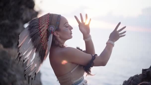 Ritratto cinematografico di maestosa donna danzante e raggi di sole, abito cerimoniale sciamanico selvaggio che indossa — Video Stock