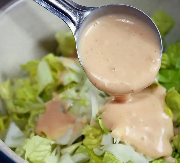 Porcionado para fora servindo de molho de salada — Fotografia de Stock