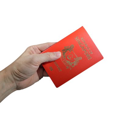El ele tutuşan Singapur pasaportu beyaz arka planda izole edilmiş, seçici odaklı. Kırpma yolu dahil. 