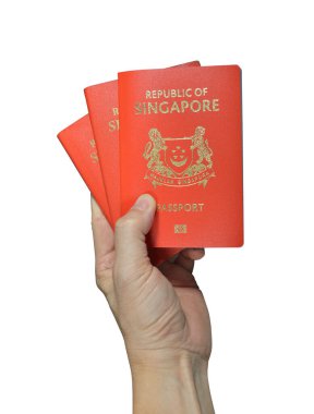 El ele tutuşan Singapur pasaportu beyaz arka planda izole edilmiş, seçici odaklı. Kırpma yolu dahil. 