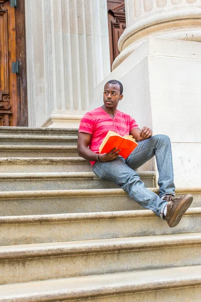 Estirando Una Pierna Sosteniendo Libro Rojo Joven Negro Está Sentado — Foto de Stock