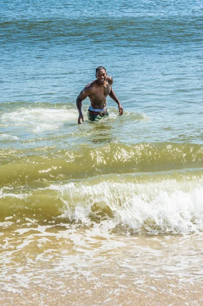 波と遊んで笑って海の水の上を歩いています彼らは波と遊んでいます — ストック写真