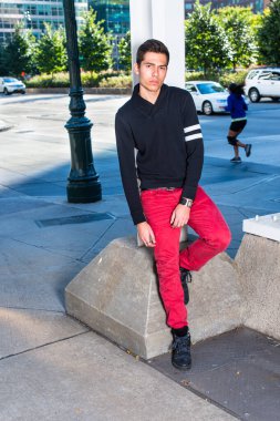 Siyah şal yakalı ve kırmızı kotlu genç bir adam metal bir yapının köşesinde seni bekliyor.