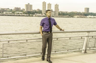 Mor gömlekli, gri pantolonlu, siyah kravatlı, sakallı, genç ve seksi bir adam nehir kenarında seni bekliyor. Filtrelenmiş etki