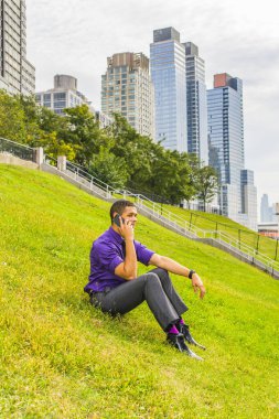 Genç adam telefonda. Mor gömlekli, gri pantolonlu, siyah kravatlı, deri ayakkabılı genç, yakışıklı bir işadamı iş yerinin dışında oturuyor ve bir cep telefonundan arama yapıyor.