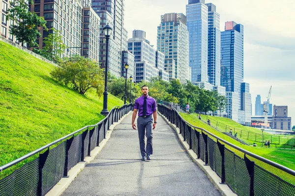 Başarı Yolu. Genç ve yakışıklı bir adam, yoğun bir iş bölgesinden kendine güvenen bir şekilde yolda yürüyor.