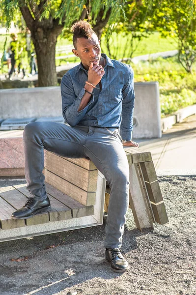 Dressing in a light blue shirt a colorful pattern tie gray pants a young  black businessman is smiling sitting outside to make a phone call on his  Stock Photo  Alamy