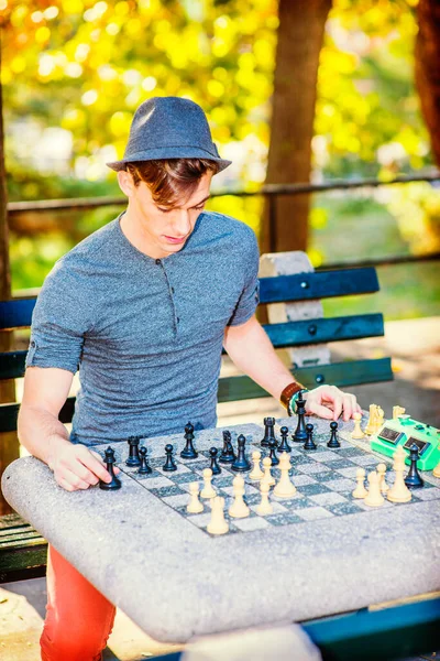 체스를 긴소매를 셔츠를 페도라 모자를 잘생긴 남자가 오후에 밖에서 체스를 — 스톡 사진