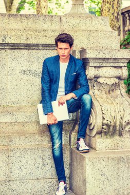 Ciddi bir Avrupalı üniversite öğrencisi New York 'ta okuyor. Mavi ceket, kot pantolon, spor ayakkabı, dizüstü bilgisayar, kampüsün köşesinde duran genç bir adam,.