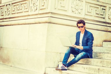 Avrupalı üniversite öğrencisi New York 'ta okuyor. Mavi ceket, kot pantolon, spor ayakkabı, güneş gözlüğü, kampüsün merdivenlerinde oturan, okuyan, düşünen, dizüstü bilgisayarda çalışan genç bir adam..