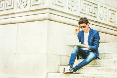 Avrupalı üniversite öğrencisi New York 'ta okuyor. Mavi ceket, kot pantolon, spor ayakkabı, güneş gözlüğü, kampüsün merdivenlerinde oturan, okuyan, düşünen, dizüstü bilgisayarda çalışan genç bir adam..