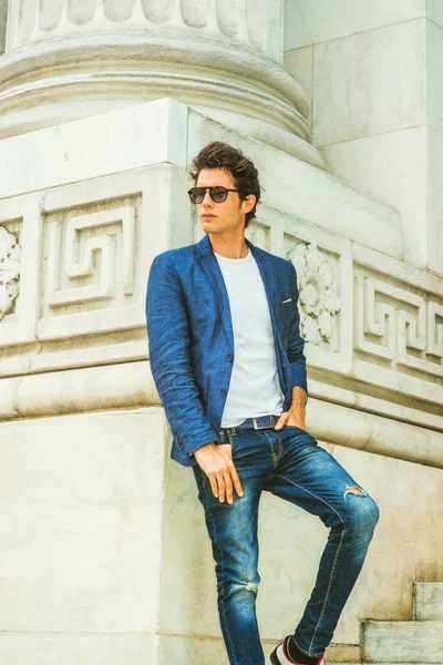 Sıradan erkek modası. Mavi ceketli, beyaz gömlekli, kot pantolonlu, güneş gözlüklü, New York 'ta kampüste köşesinde dikilen genç Avrupalı bir üniversite öğrencisi..