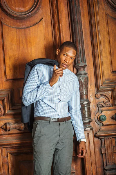 New York 'ta çalışan Afrikalı Amerikalı iş adamı. Çizgili gömleği, gri pantolonu, omuzda el işi ceketi, eski tarz sınıfın yanında duran genç bir öğretmen, sana bakıyor.