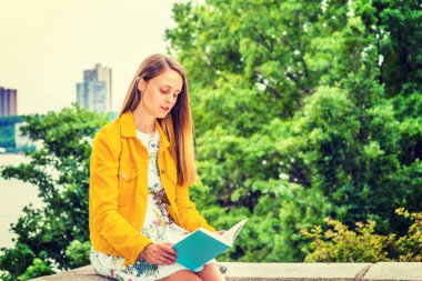 New York 'ta okuyan Amerikalı bir üniversite öğrencisi. Çiçek desenli iç çamaşırı giyen güzel bir kız, sarı kadife ceket, elinde yeşil kitap, kampüsteki ağaçların yanında oturuyor, aşağı bakıyor, okuyor.