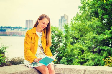 New York 'ta okuyan Amerikalı bir üniversite öğrencisi. Çiçek desenli iç çamaşırı giyen güzel bir kız, sarı kadife ceket, elinde yeşil kitap, kampüsteki ağaçların yanında oturuyor, aşağı bakıyor, gülümsüyor, okuyor.