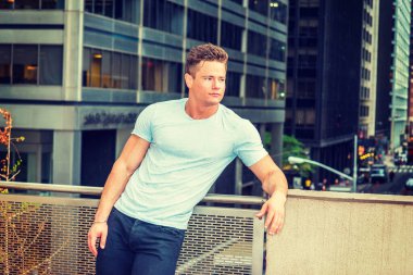 Yağmurlu bir günde düşünen ateşli bir Amerikan işçisi, kumlu, sisli, yağmurlu bir arka plan. Beyaz tişörtlü, genç seksi bir adam New York 'ta balkonda dikiliyor, eğik vücutlu, başka tarafa bakıyor, seni bekliyor..