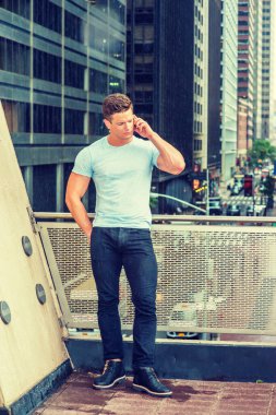 Yağmurlu bir günde telefonda konuşan Amerikalı işçiler, bulanık, sisli, yağmurlu bir arka plan. Beyaz tişörtlü, siyah pantolonlu, spor ayakkabılı, New York 'ta balkonda duran, cep telefonuyla konuşan genç bir adam.