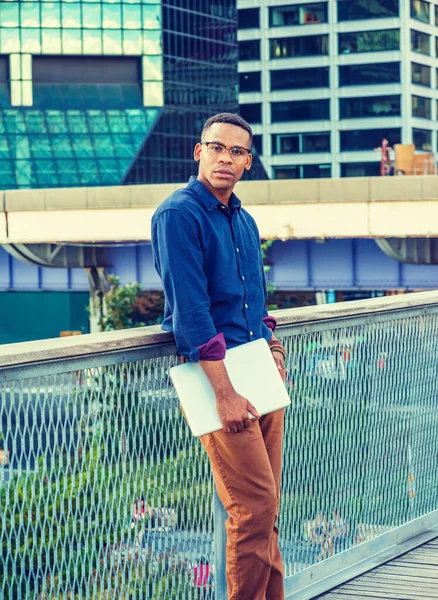 Genç Afro-Amerikan Adam Büyük Şehir 'de büyüdü. Mavi gömlekli, gözlüklü, dizüstü bilgisayarı olan, yüksek binalarla iş bölgesinde çitlere karşı duran siyahi bir üniversite öğrencisi..