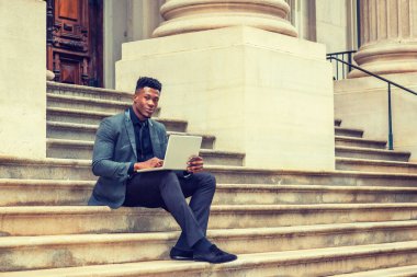 New York 'ta çalışan Afrikalı Amerikalı iş adamı. Şık bir ceket, kravat, kampüsün dışındaki merdivenlerde oturan genç bir öğrenci dizüstü bilgisayarla çalışıyor. Filtrelenmiş etki