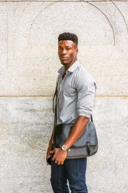 İşe giden bir adam var. Gri gömlekli, kot pantolonlu, kol saati takan, omuz derisi çanta taşıyan, sokakta duvarda dikilmiş kulaklık ve cep telefonuyla müzik dinleyen Afro-Amerikalı bir adam.