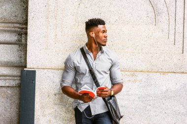 New York 'taki modern üniversite öğrencisi. Gri gömlekli, kol saati takan, omuz derisi çanta taşıyan, duvarda dikilmiş, kulaklıkla müzik dinleyen, kırmızı kitap okuyan...