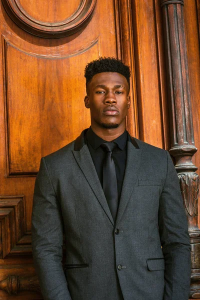 New York 'ta çalışan Afrikalı Amerikalı iş adamı. Modaya uygun bir ceket, siyah atlet, kravat, küçük keçi sakallı genç bir adam, klasik tarz kapının önünde duruyor, kendine güvenen bir şekilde sana bakıyor..