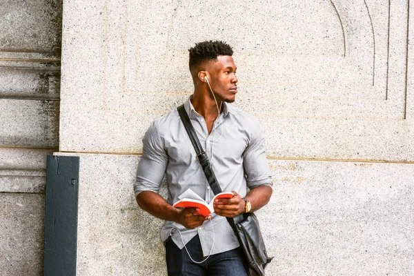 New York 'taki modern üniversite öğrencisi. Gri gömlekli, kol saati takan, omuz derisi çanta taşıyan, duvarda dikilmiş, kulaklıkla müzik dinleyen, kırmızı kitap okuyan...