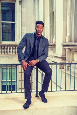 New York 'ta çalışan Afro-Amerikalı iş adamı, şık bir ceket giyiyor, siyah kravat takıyor, kol saati takıyor, eski moda ofis binasında korkuluklara oturuyor, mola veriyor.. 